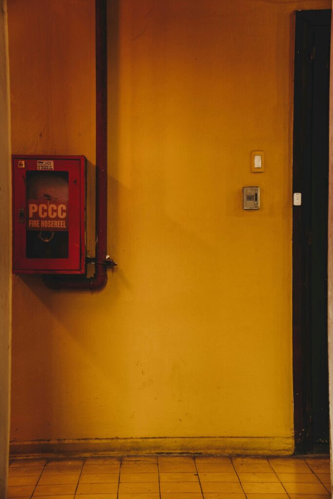 Interior view of a yellow wall with a fire hose reel, captured in a building in Saigon, Vietnam.